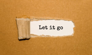 The text Let it go appearing behind torn brown paper